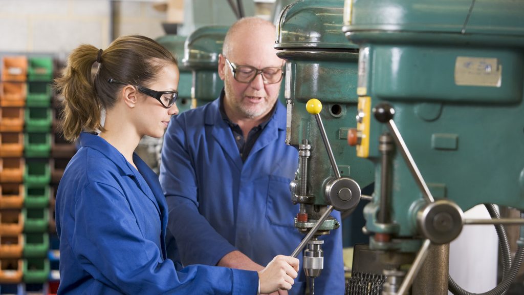 Two machinists working on machine