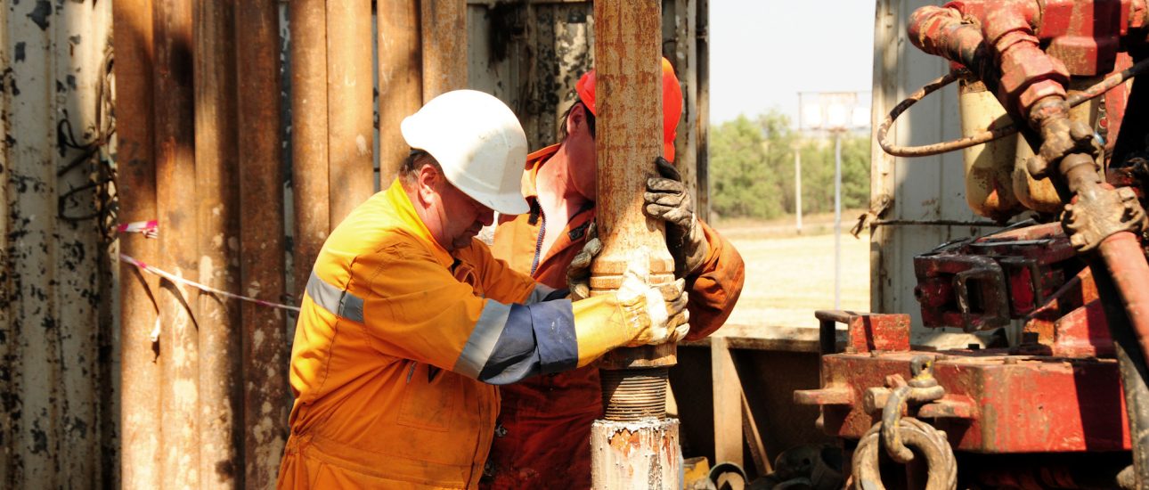 Drilling rig workers in orange uniform