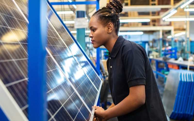 Quality engineer examining solar panels in factory
